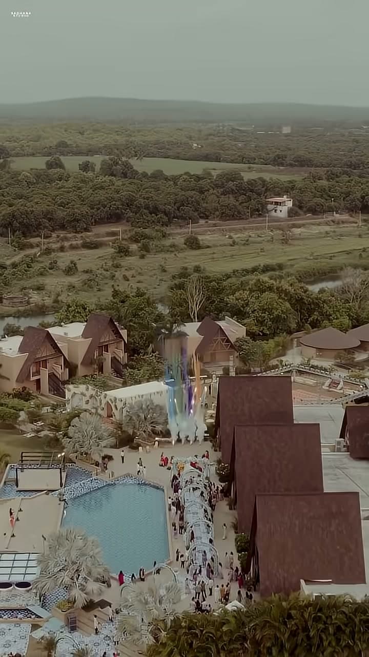 Aerial view of Jagira Ananta Elite showing the poolside Haldi Carnival setup, floral archway walkway, and surrounding Gir countryside