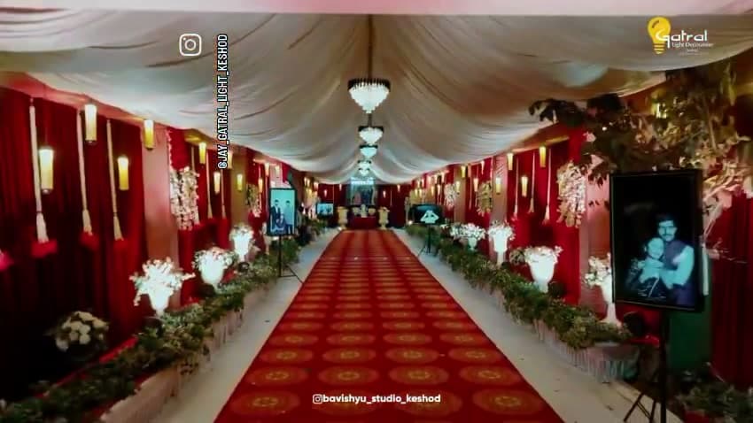Guest corridor with swagged white and red ceiling drapes, a row of crystal chandeliers, red carpet and flower urns along the sides