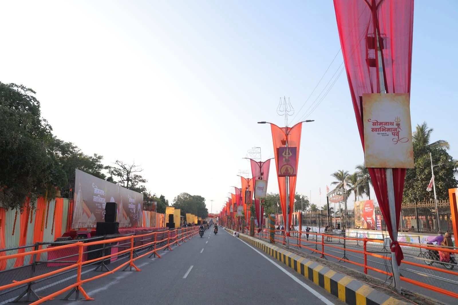 Long stretch of road lined with saffron and red flag banners and festival signage leading toward the temple